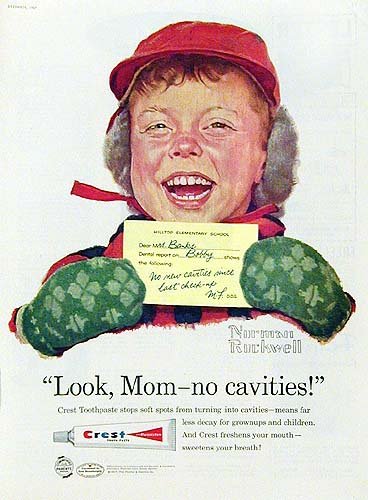 Squinty open smile on a boy wearing a red winter hat and green mittens and holding a yellow exam note says 'Look Mom no cavities' in another Crest toothpaste ad print by Norman Rockwell.