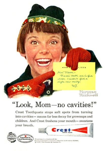 Norman Rockwell painting of a girl in a brown bob and green cap points to a yellow note about her dental checkup and yells 'Look, Mom - no cavities!' Ad copy: Crest Toothpaste stops soft spots from turning into cavities - means far less decay for grownups and children. And Crest freshens your mouth - sweetens your breath.