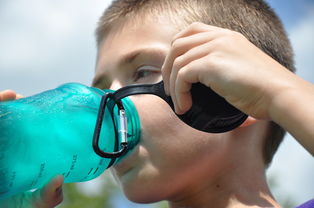 Boy drinks fluoridated water from bottle