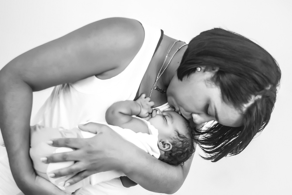 A mom kisses her baby on the head