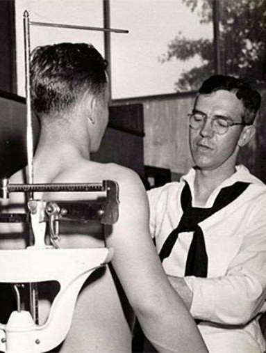 WW2 recruit being weighed by a health practitioner